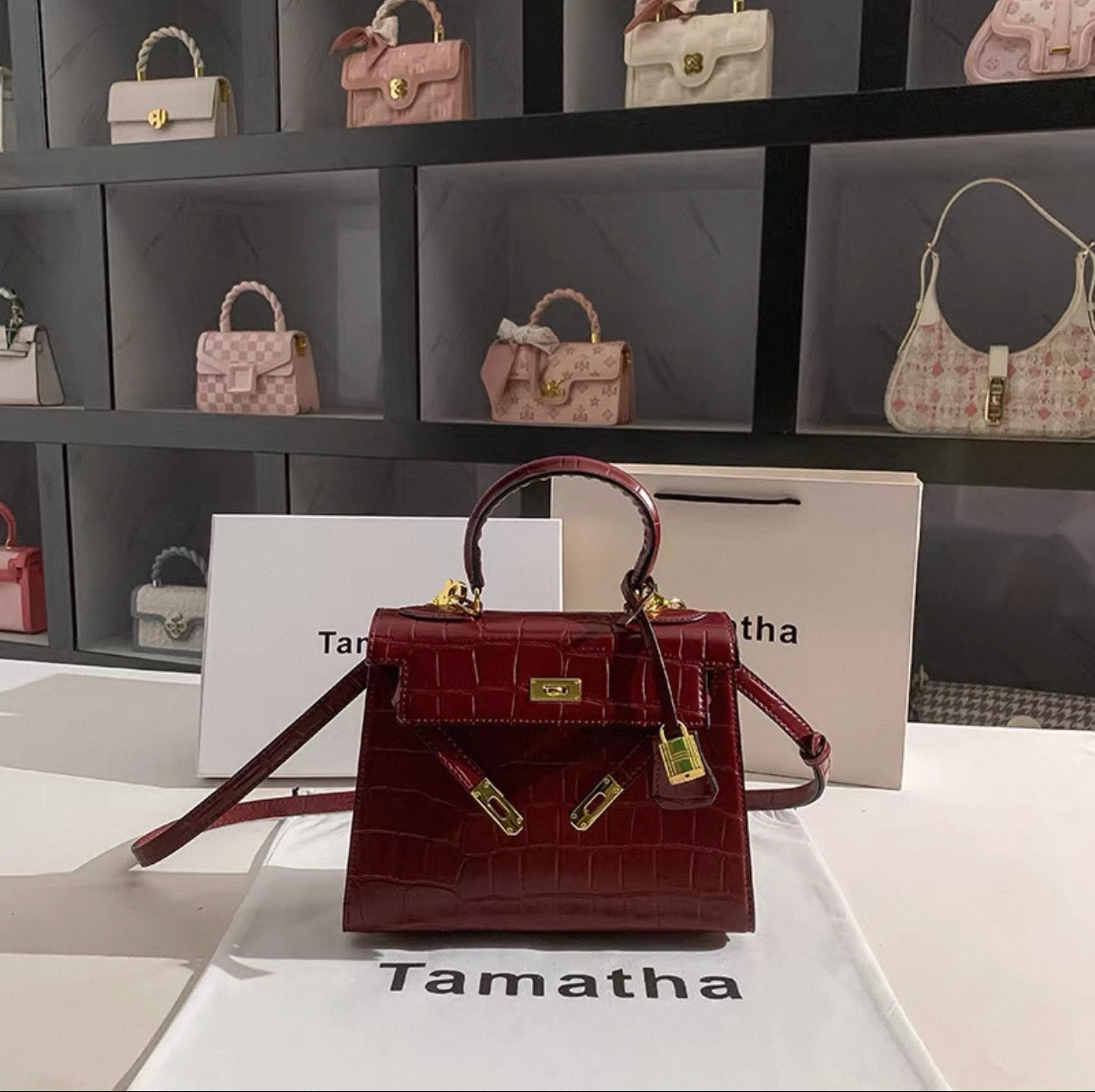 Ruby red Kelly-style bridal bag with stone-pattern texture, gold lock and hardware, top handle and detachable shoulder strap.
