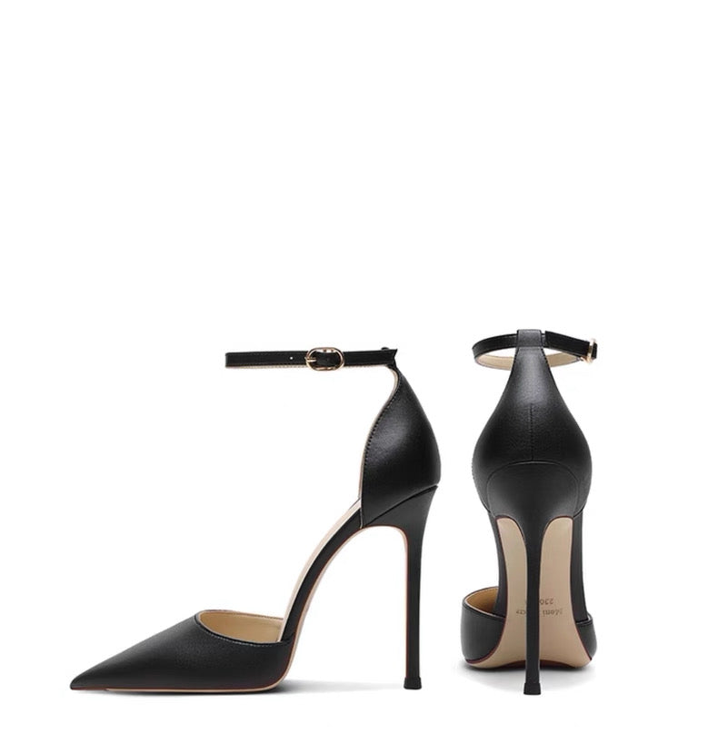 Black leather stiletto heels with pointed toes and thin ankle straps with gold buckles.
