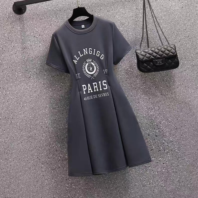 Gray dress with 'ALLNGIGG PARIS' text and a black handbag on a textured surface