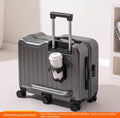 Gray suitcase with a cup holder containing a coffee cup on a light background