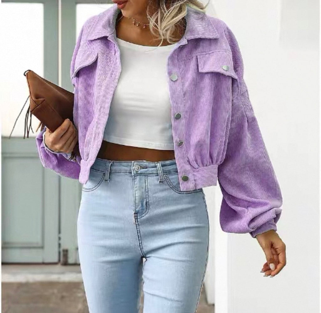 Person wearing a purple corduroy jacket, white top, and light blue jeans.