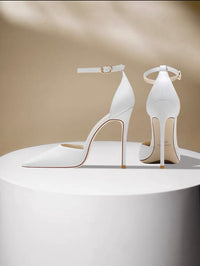 Nude leather stiletto heels with pointed toes and ankle straps, featuring hollow sides and slender high heels.