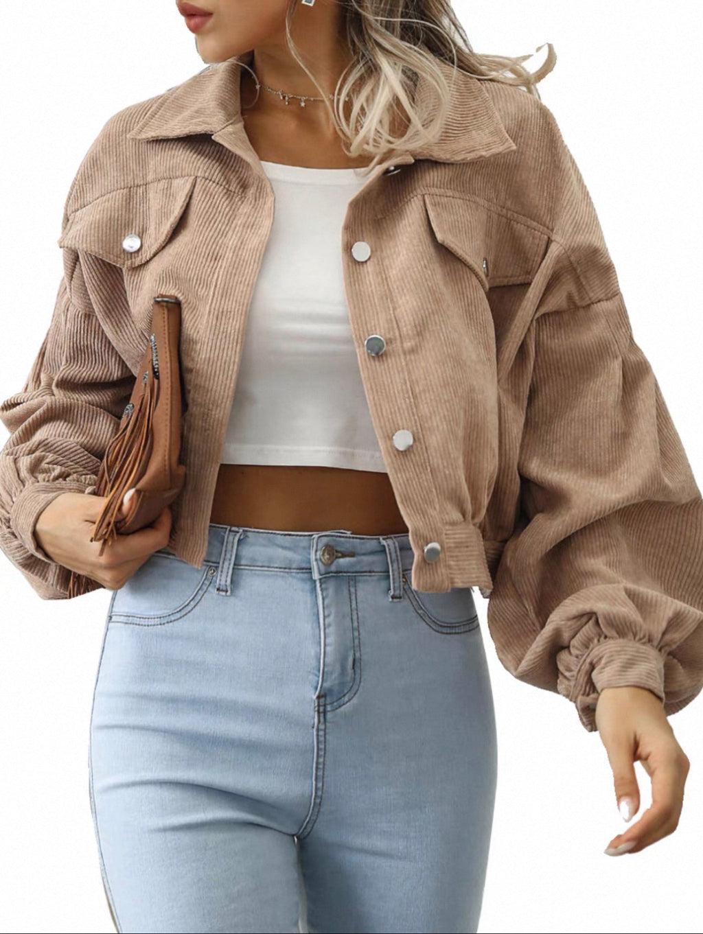 Person wearing a beige corduroy jacket, white top, and light blue jeans on a white background