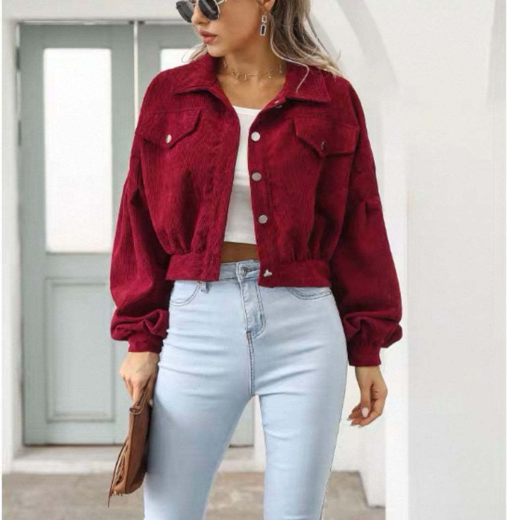 Person wearing a red jacket and light blue jeans indoors