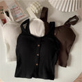 Three ribbed knit tops in black, white, and brown on a light surface.