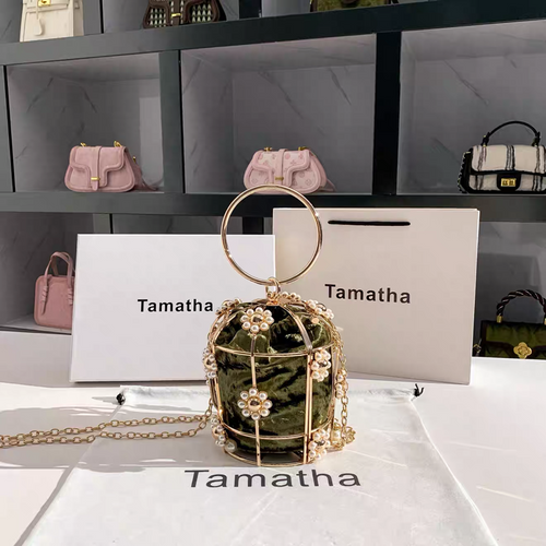 Green handbag with gold chain and handle on a white surface with 'Tamatha' branding.