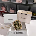 Pink handbags displayed on shelves with 'Tamatha' branding.