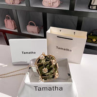 Pink handbags displayed on shelves with 'Tamatha' branding.