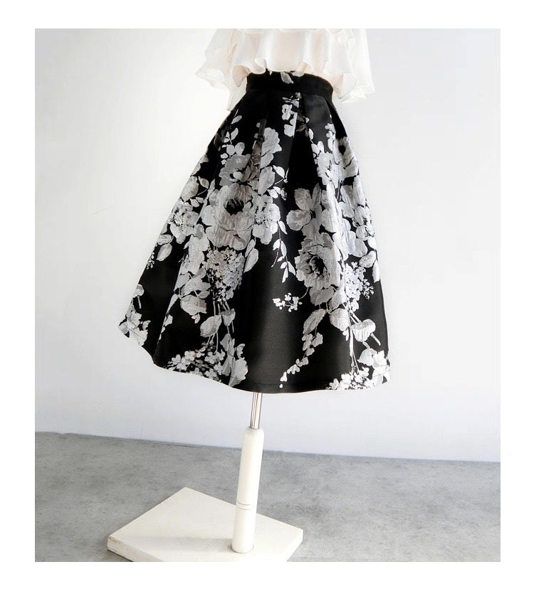 Black skirt with white floral pattern on a mannequin against a white background