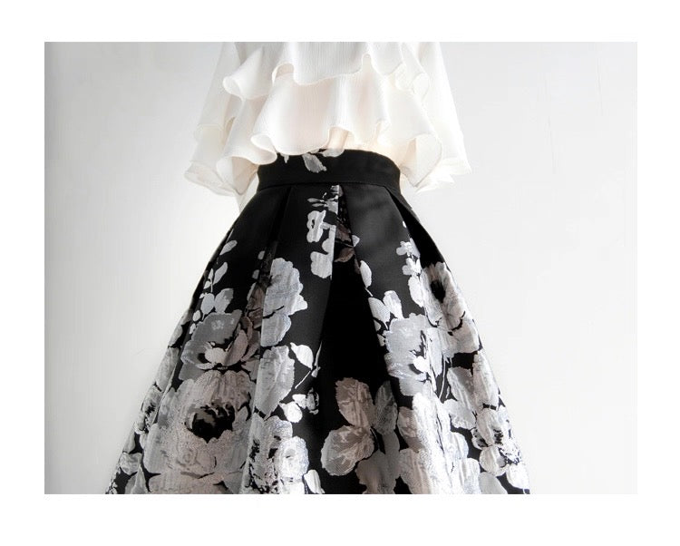 Black floral skirt with white blouse on a light gray background