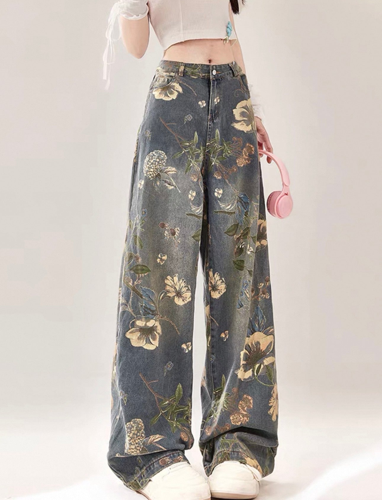 Floral-patterned jeans worn by a person on a white background