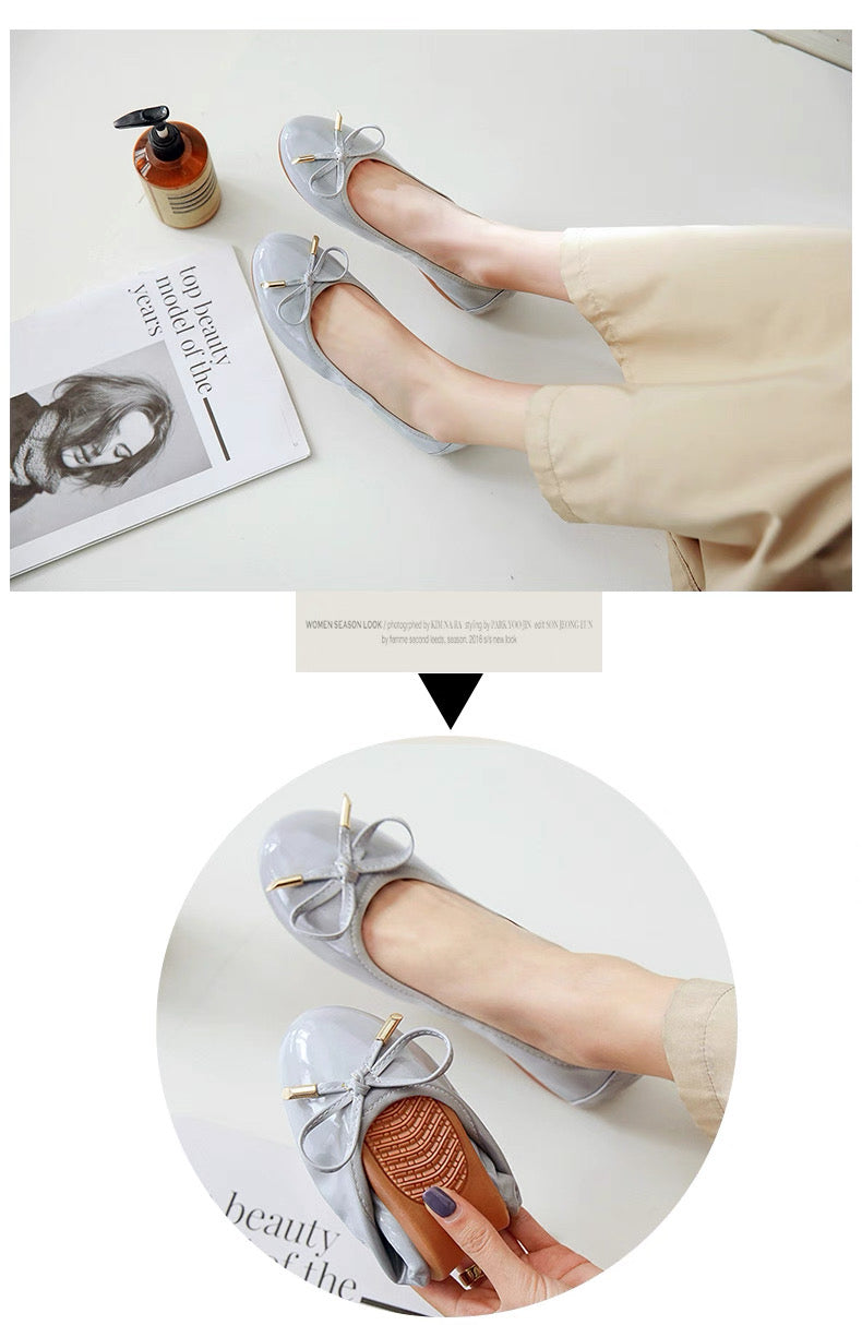 Gray flat shoes with bow details worn by a person, displayed on a white surface.