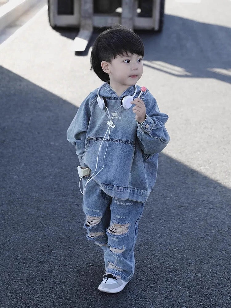 Child wearing a denim outfit standing on a road