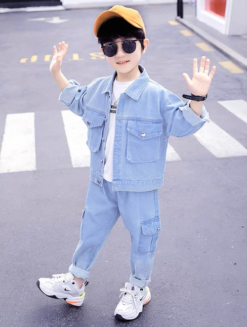 Child wearing a light blue denim outfit with sunglasses and a yellow cap on a road.