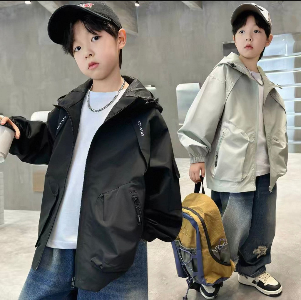 Two children wearing jackets in an indoor setting