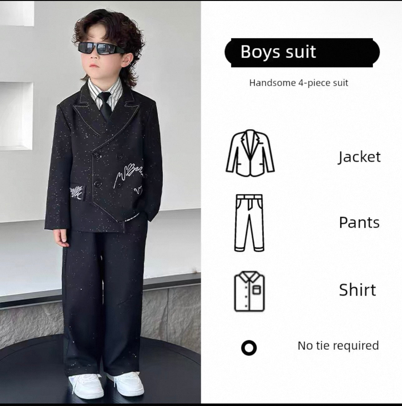 Young boy wearing a formal boys' suit with sunglasses, standing against a neutral background.