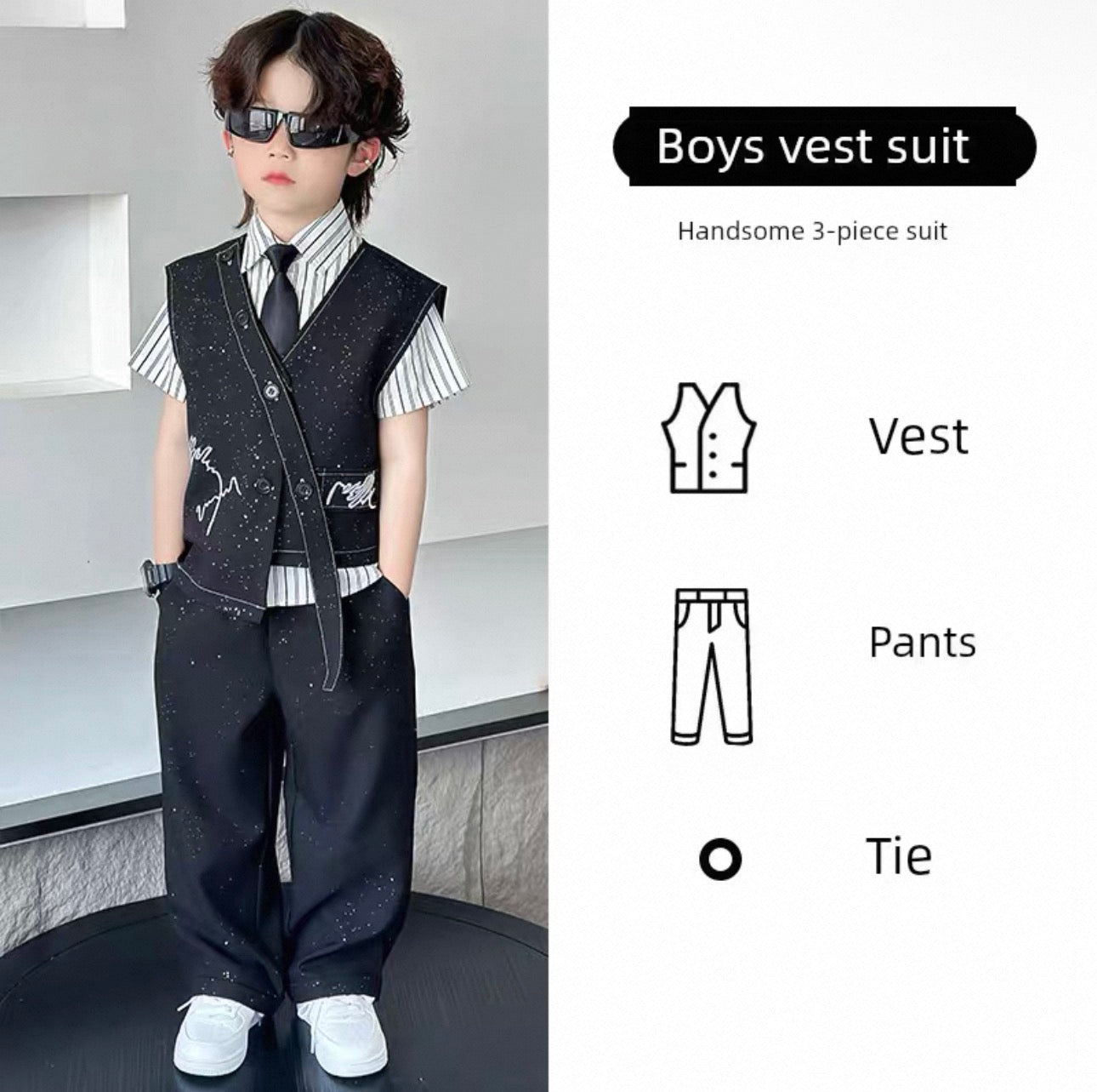 Young boy wearing a boys' vest suit with sunglasses, standing against a neutral background.