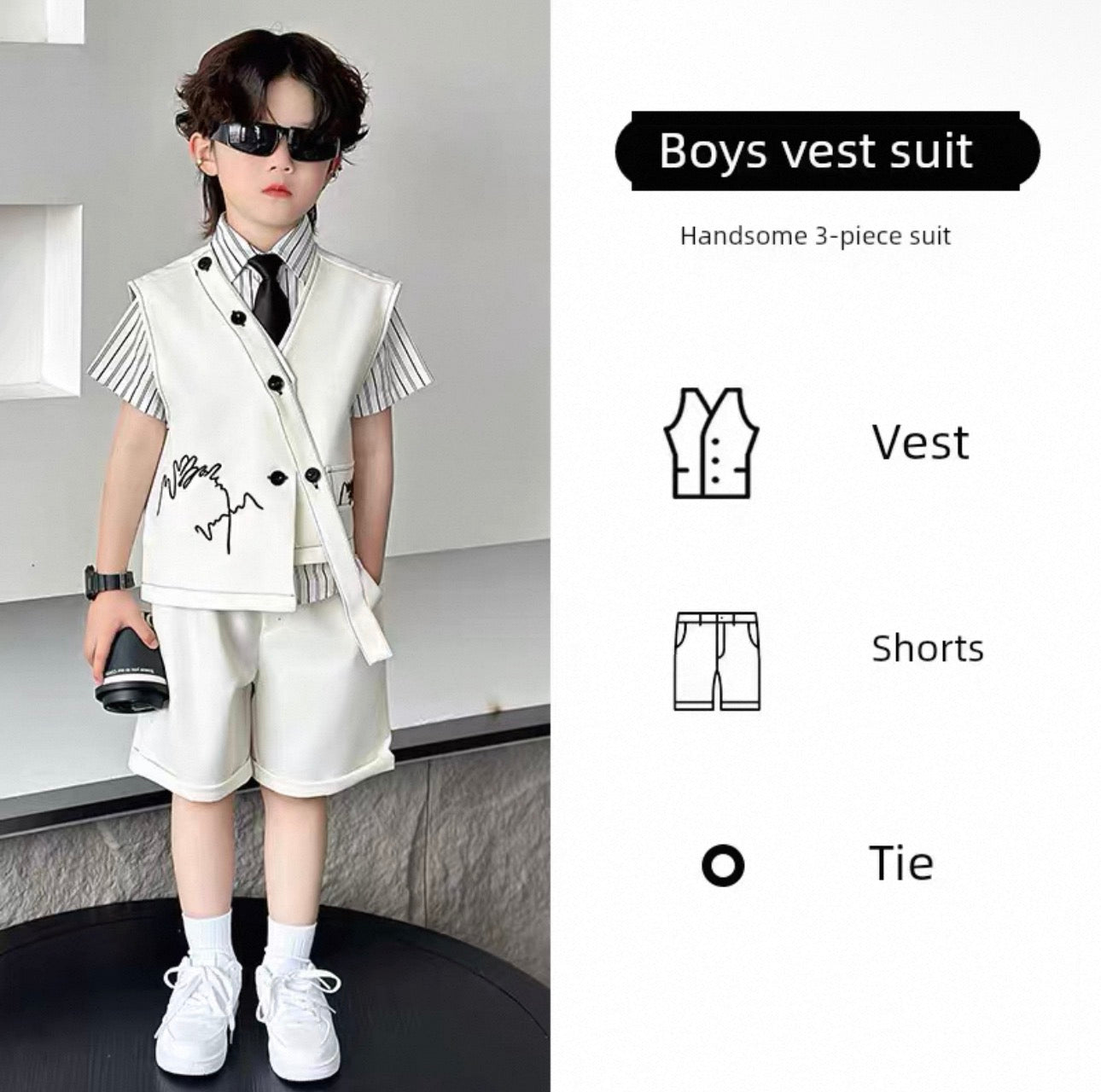 Young boy wearing a boys' vest suit with vest, shorts, and tie on a modern interior background.