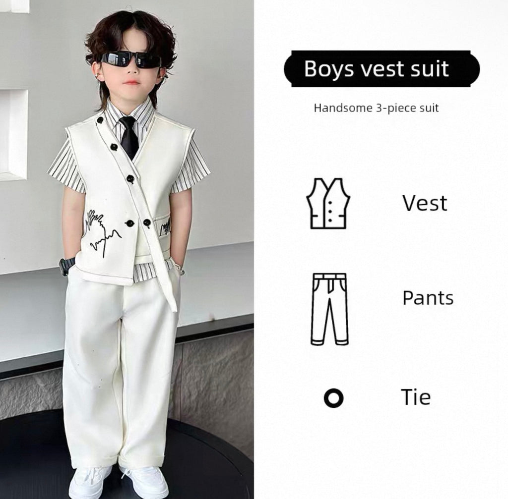 Young boy wearing a white vest suit with sunglasses, standing against a neutral background.