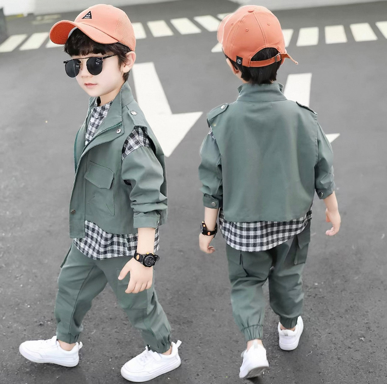 Two children in matching green outfits with plaid shirts on a road.
