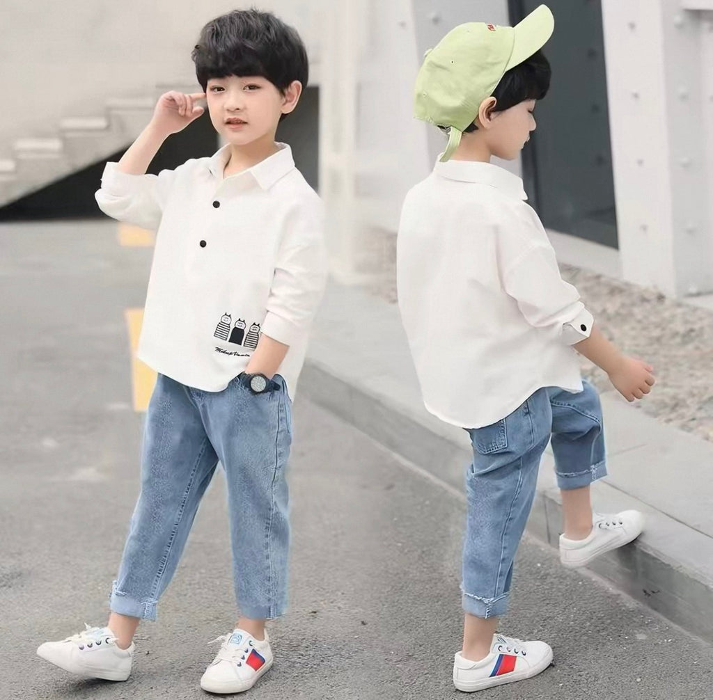 Two children wearing white shirts and blue jeans standing on a sidewalk.