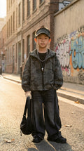 Child standing on a street with graffiti in the background