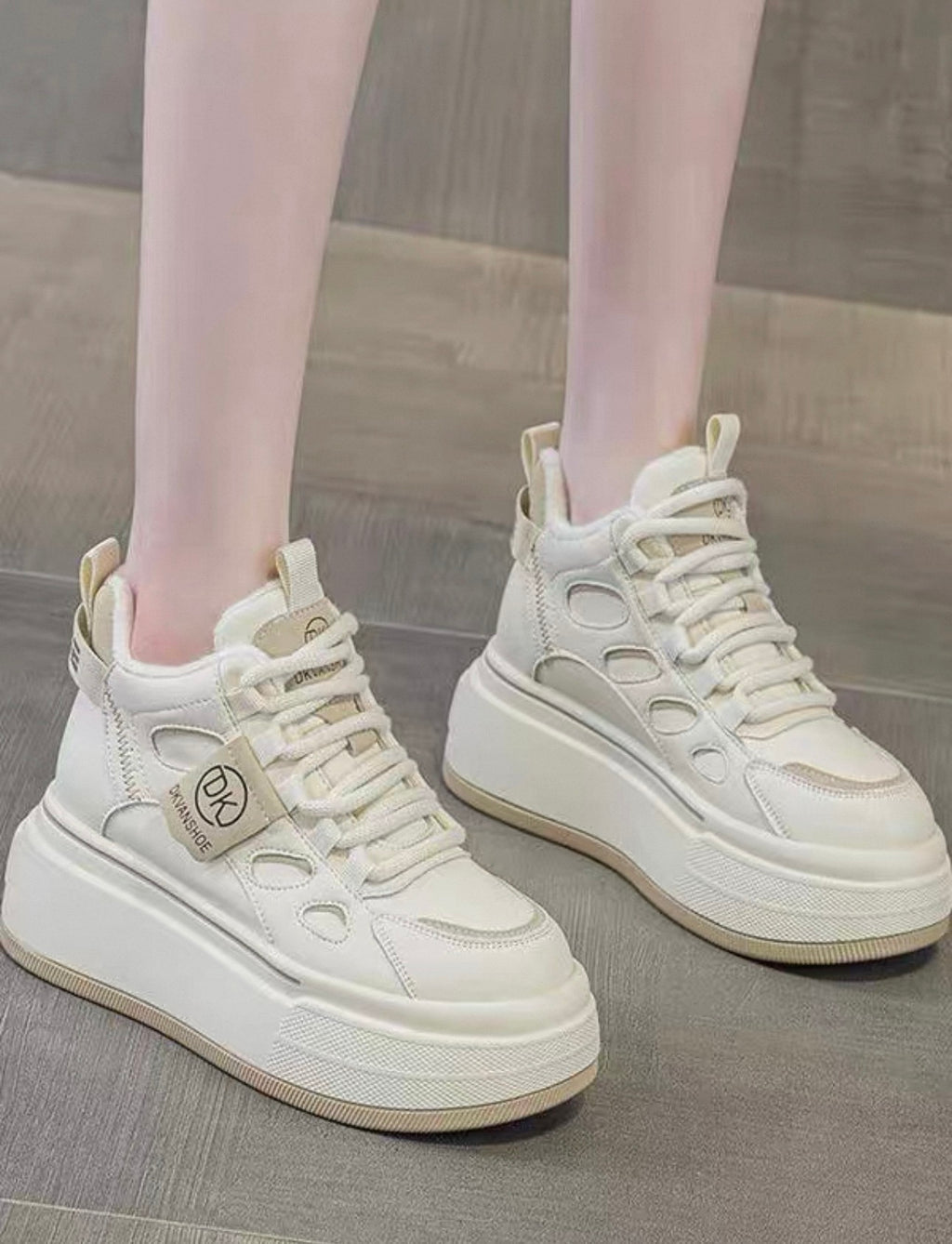 White sneakers with a brand tag on a neutral background