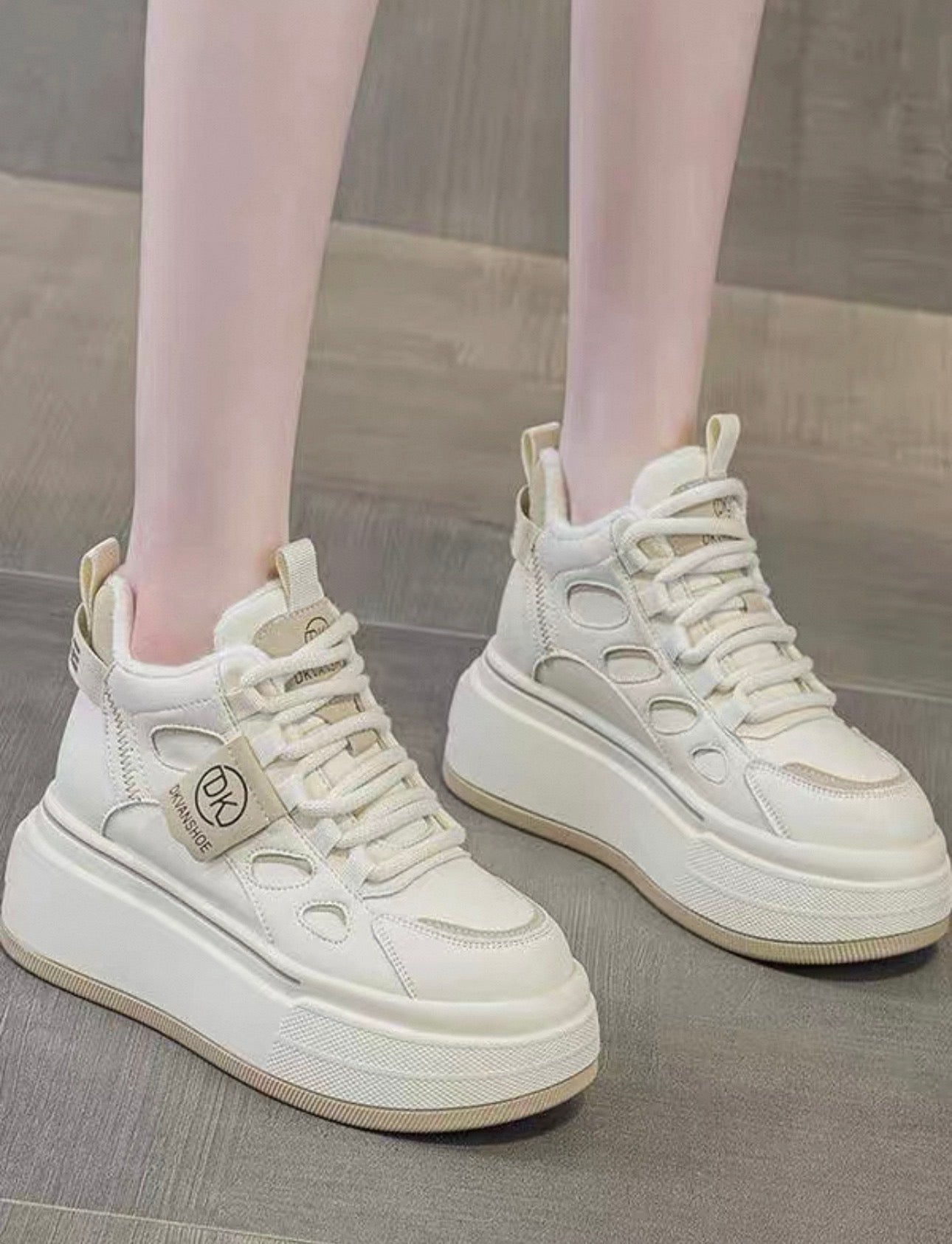 White sneakers with a brand tag on a neutral background