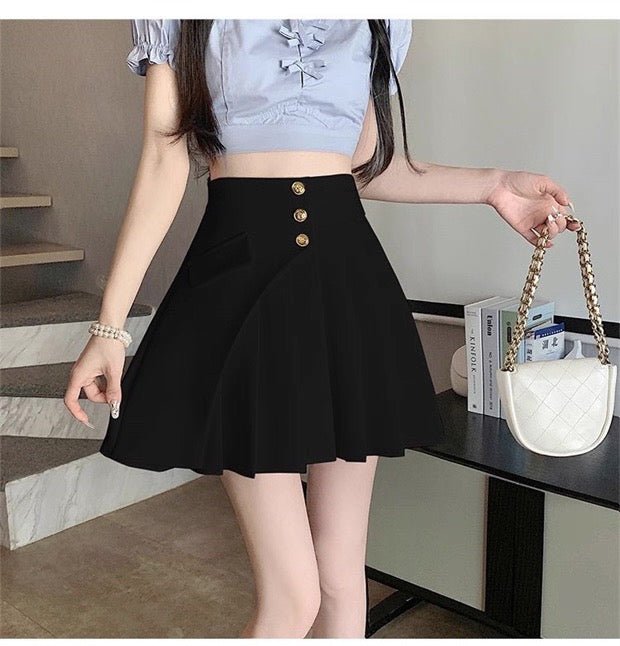 Person wearing a black skirt with gold buttons in an indoor setting