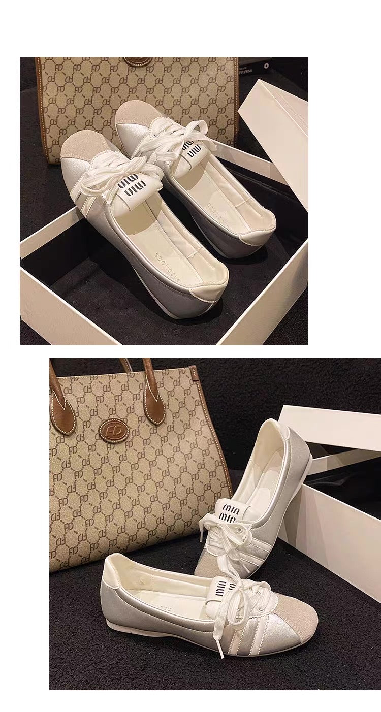 White shoes with bow details in a box, bag in the background