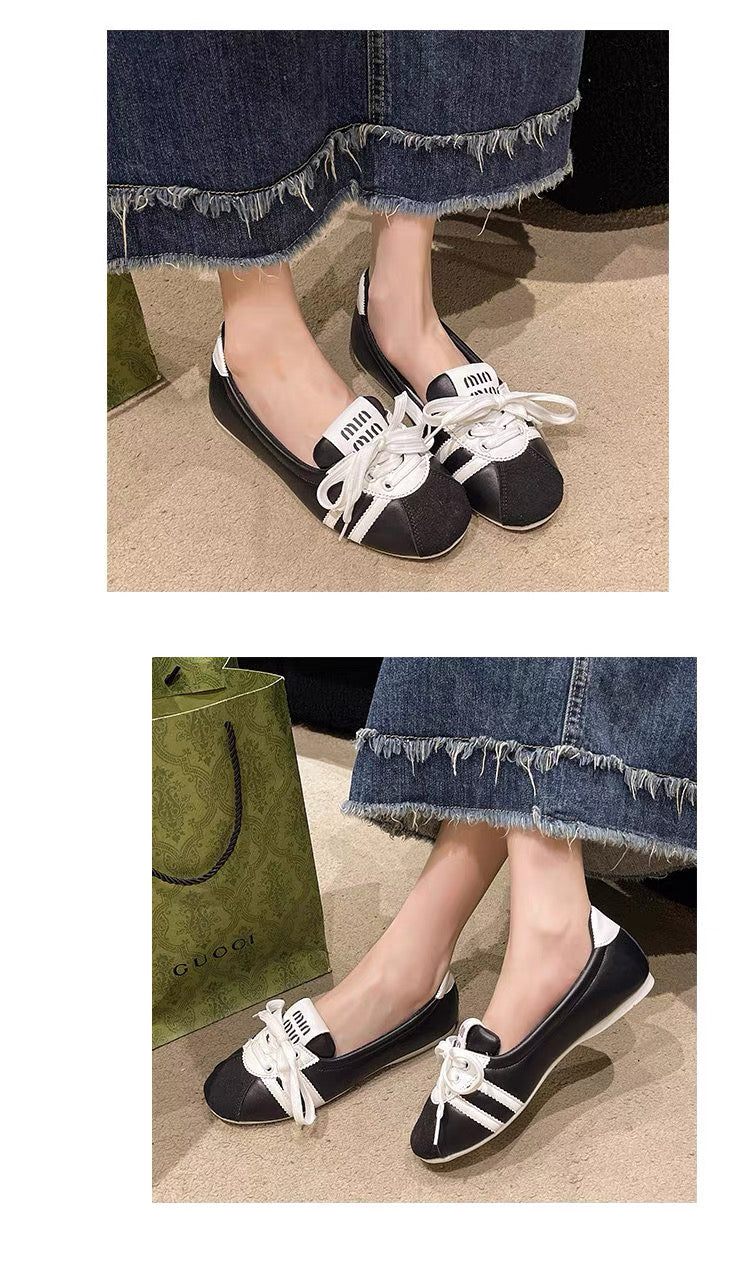 Black and white shoes worn with denim jeans on a neutral background