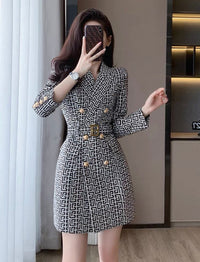 Woman wearing a patterned dress taking a mirror selfie.