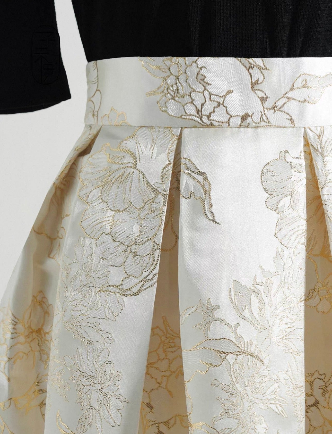 White floral-patterned skirt with gold accents on a plain background