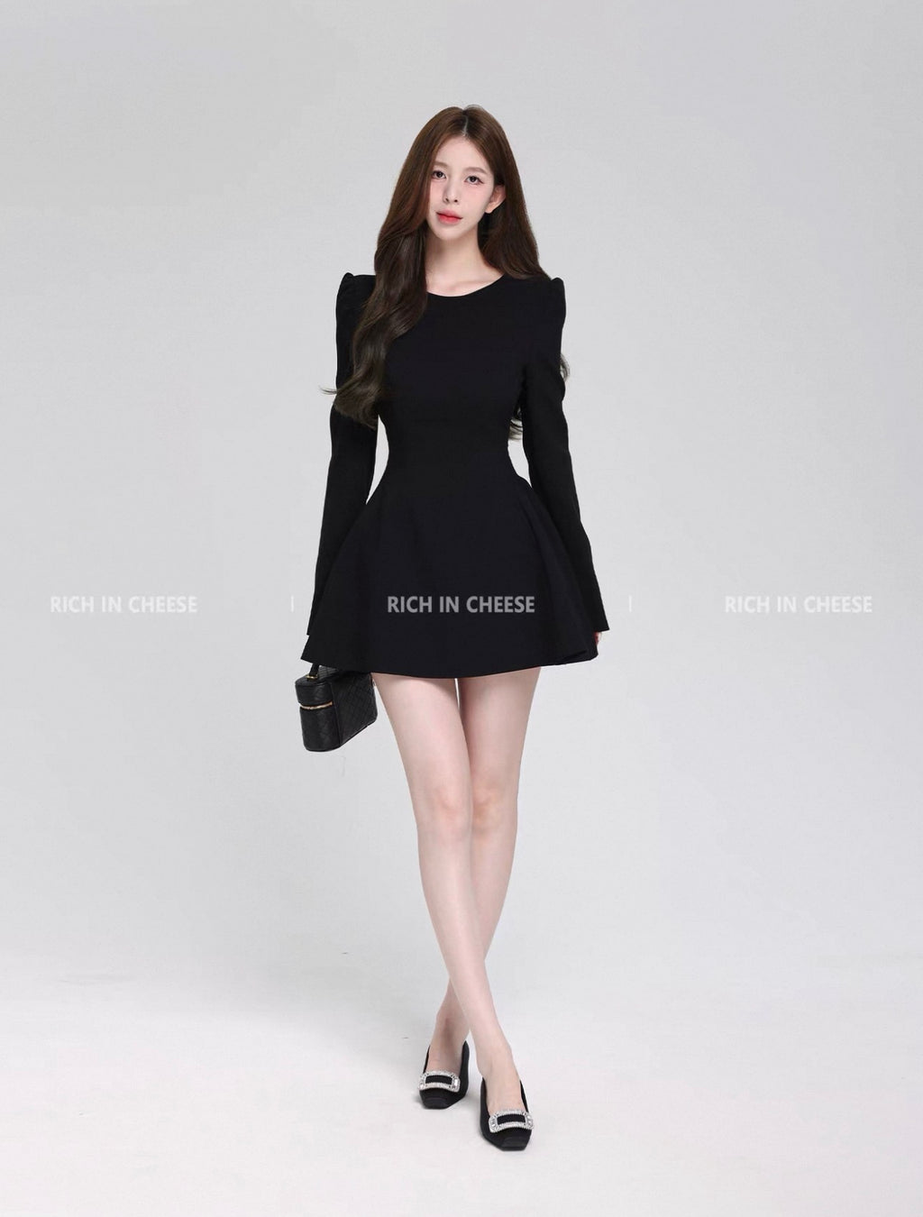 Woman wearing a black dress on a white background with 'RICH IN CHEESE' branding.