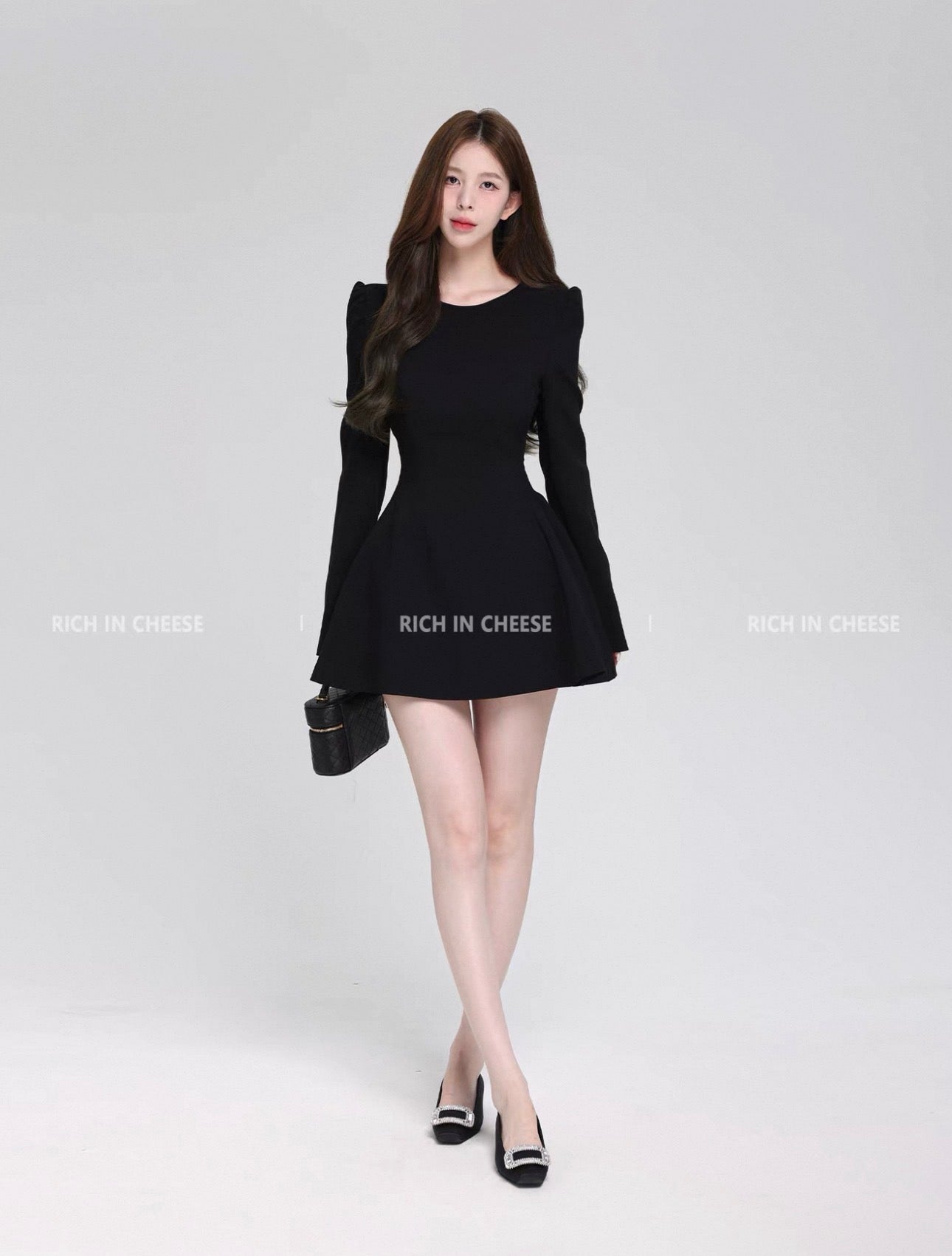 Woman wearing a black dress on a white background with 'RICH IN CHEESE' branding.