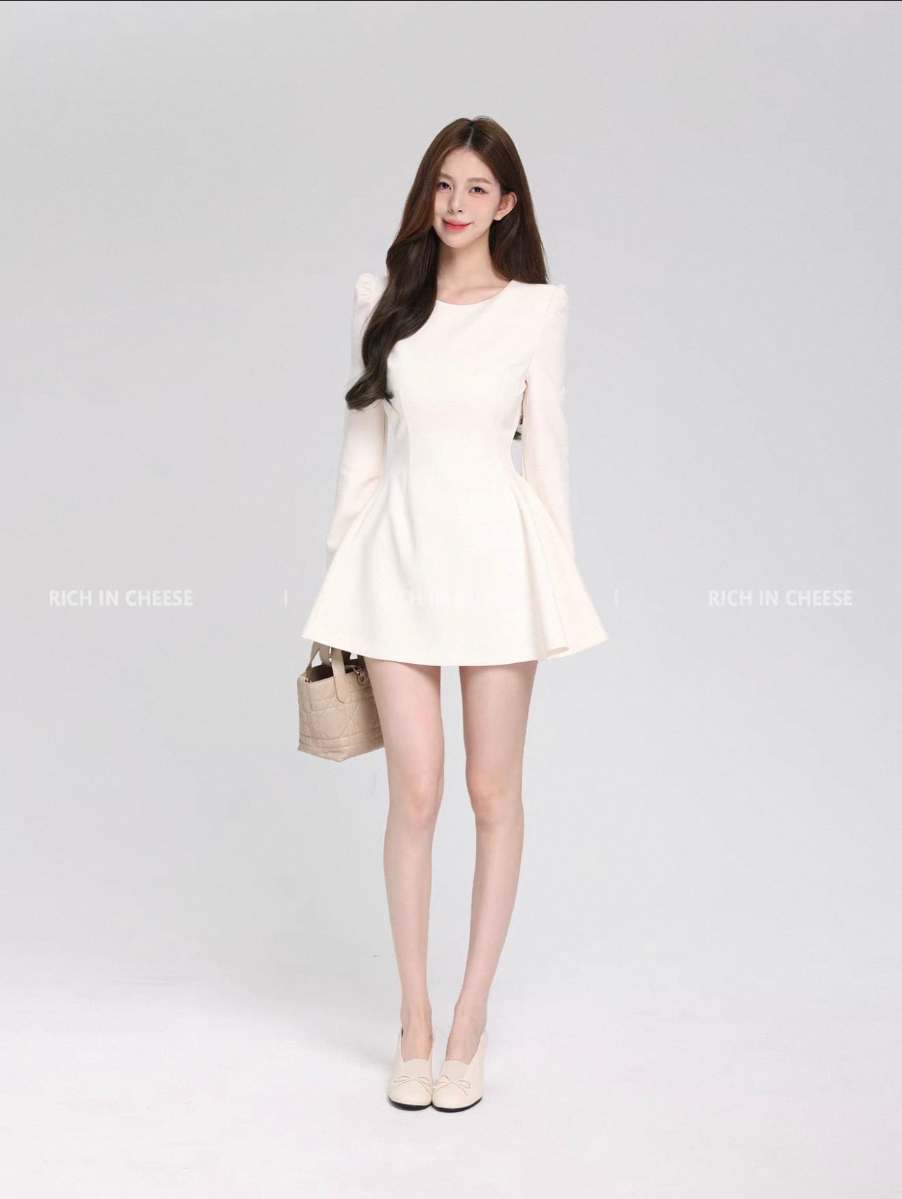 Woman wearing a white dress with a plain background