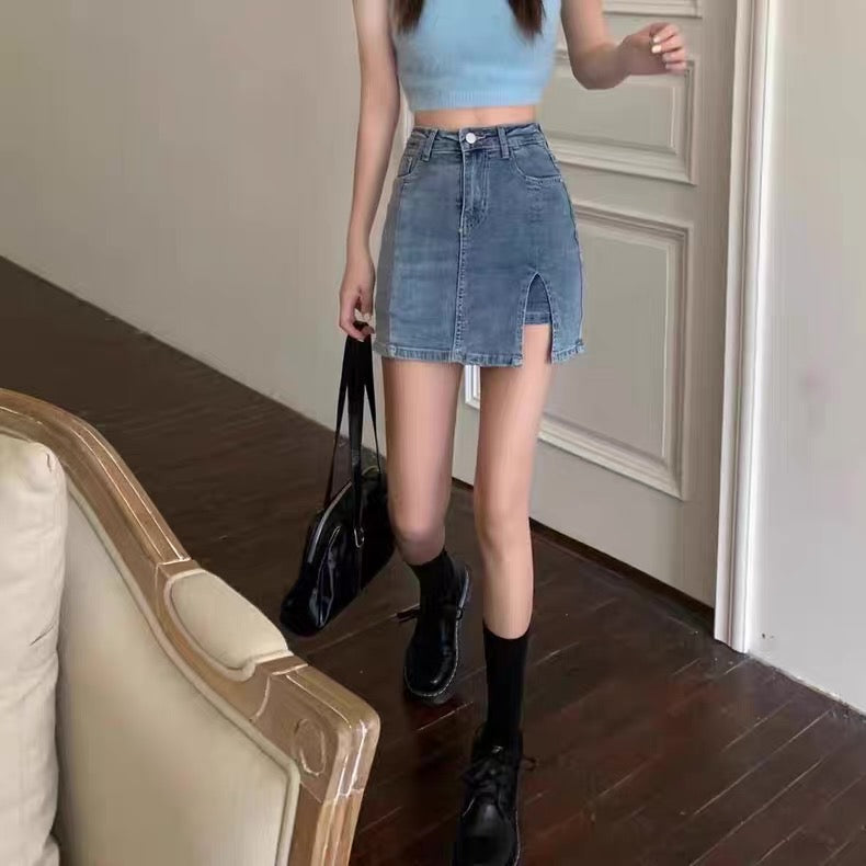 Person wearing a blue denim skirt and black shoes in a room with a beige sofa.