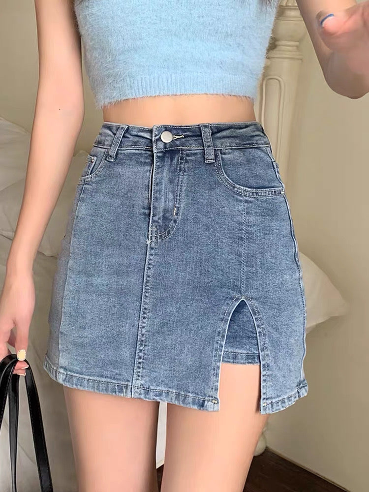 Person wearing a light blue crop top and denim skirt with a neutral background