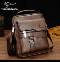 Brown leather crossbody bag with visible YUESKANGAROO branding on a wooden surface.