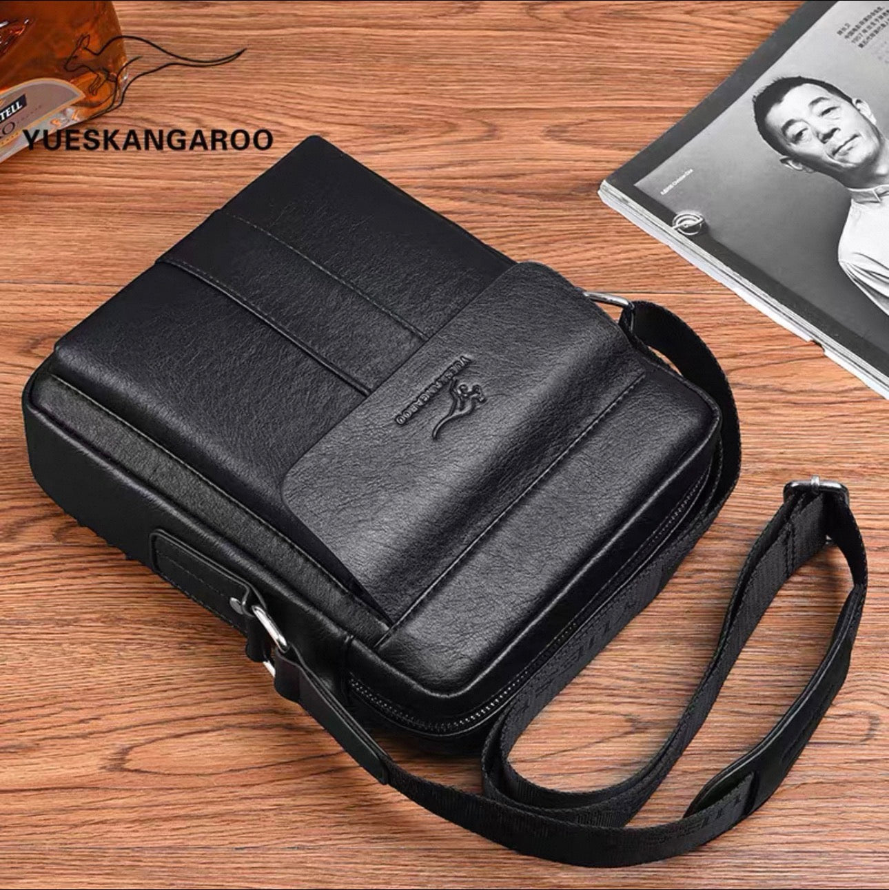Black leather briefcase on a wooden surface with 'YUESKANGAROO' branding.