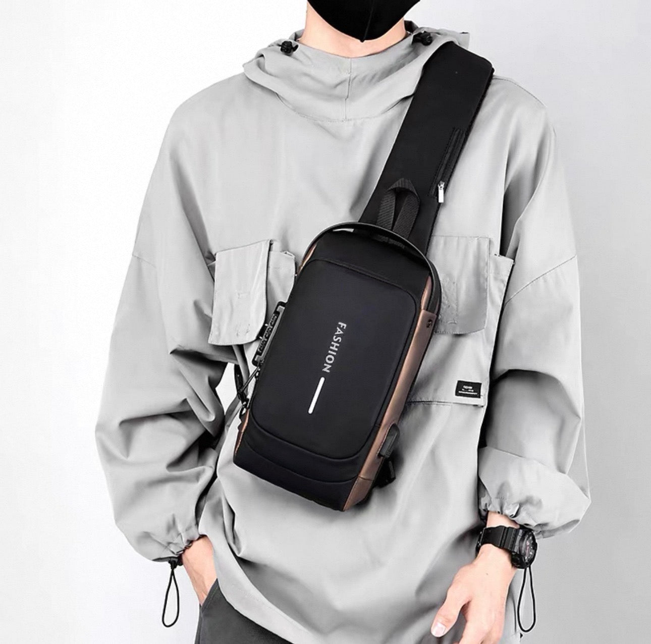 Person wearing a black crossbody bag with 'FASHION' text on a light gray background