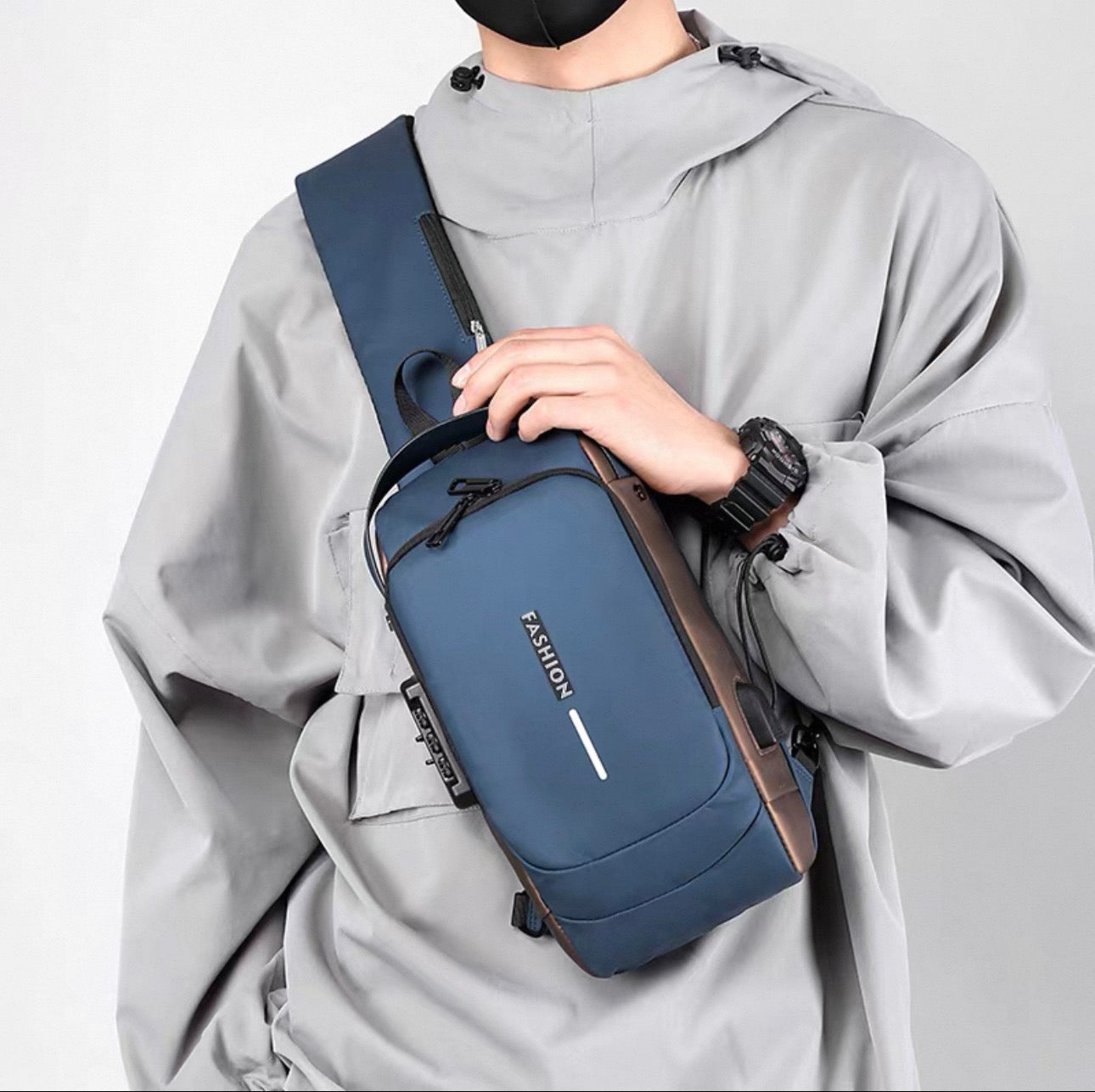 Person wearing a gray raincoat holding a blue crossbody bag with 'FASILION' branding.