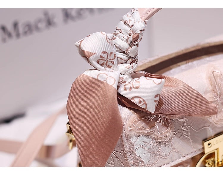 Close-up of a decorative shoe with a bow and lace details, blurred background.