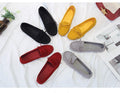 Set of colorful loafers on a white surface with a magazine underneath.