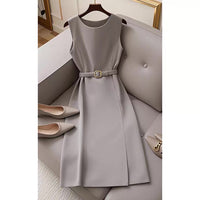 Gray dress with a belt on a hanger against a neutral background