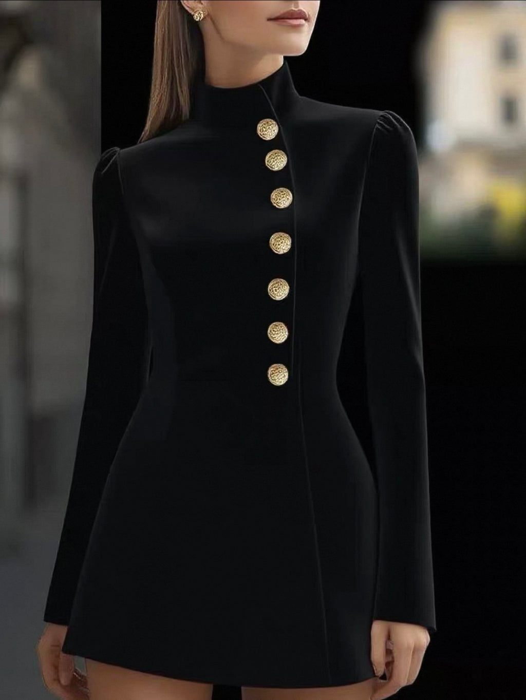 Black dress with gold buttons worn by a model against a blurred background