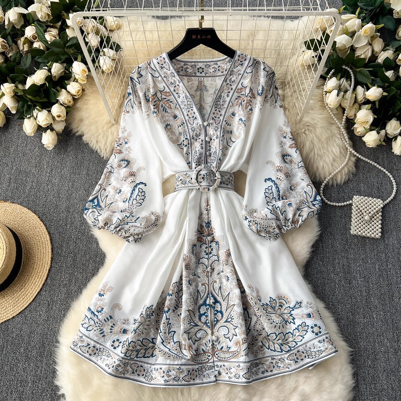 Floral-patterned dress on a hanger with decorative items around