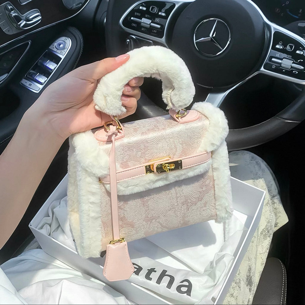 Pink Kelly-style handbag with gold hardware and soft white faux fur trim, top handle design.
