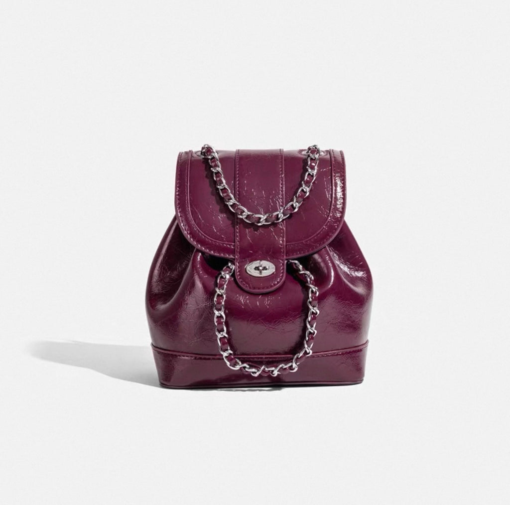 Purple backpack with chain detail on a white background