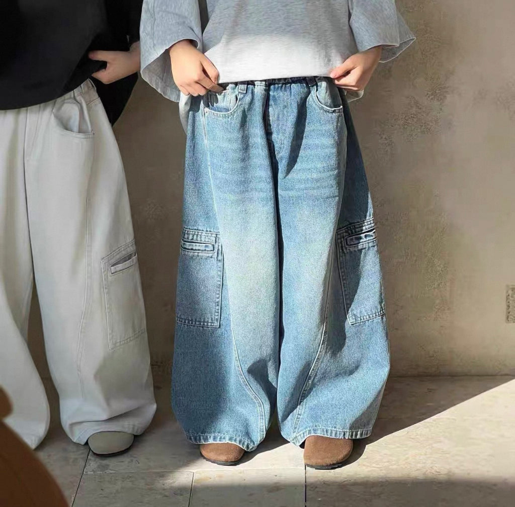 Person wearing wide-leg jeans with a plain background